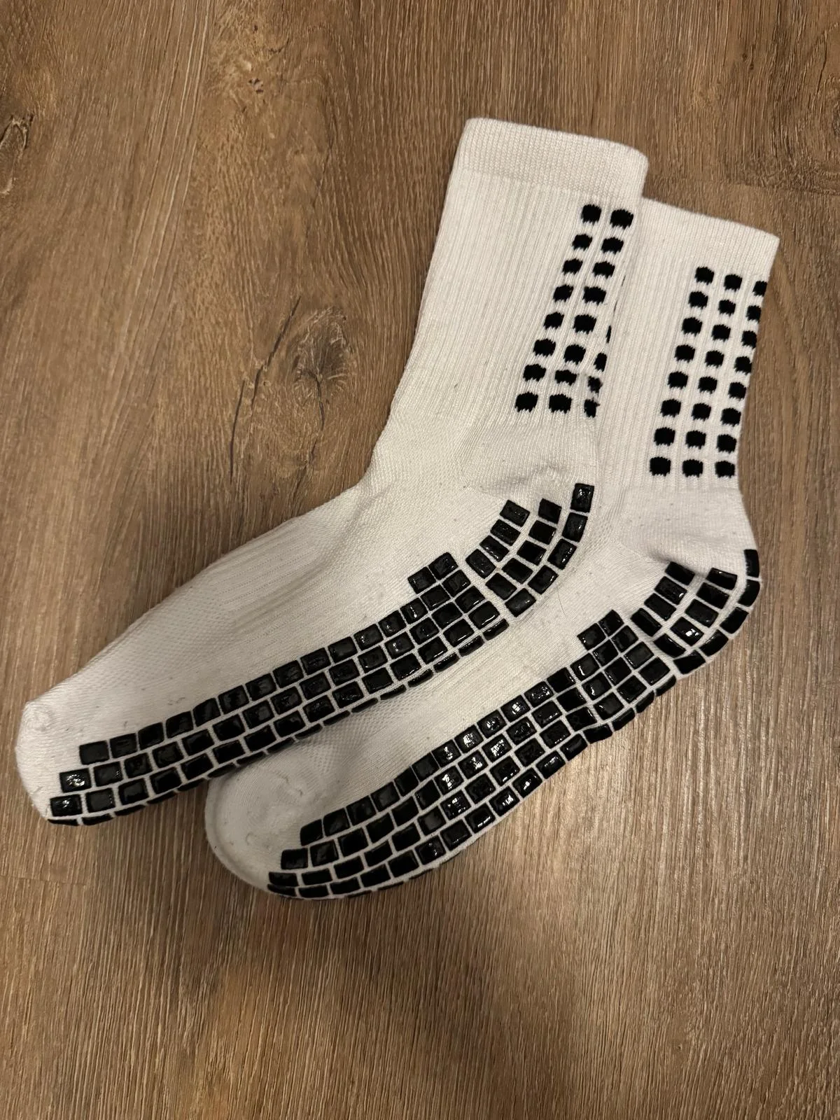 Chaussettes grip blanches et leur motif de semelle.