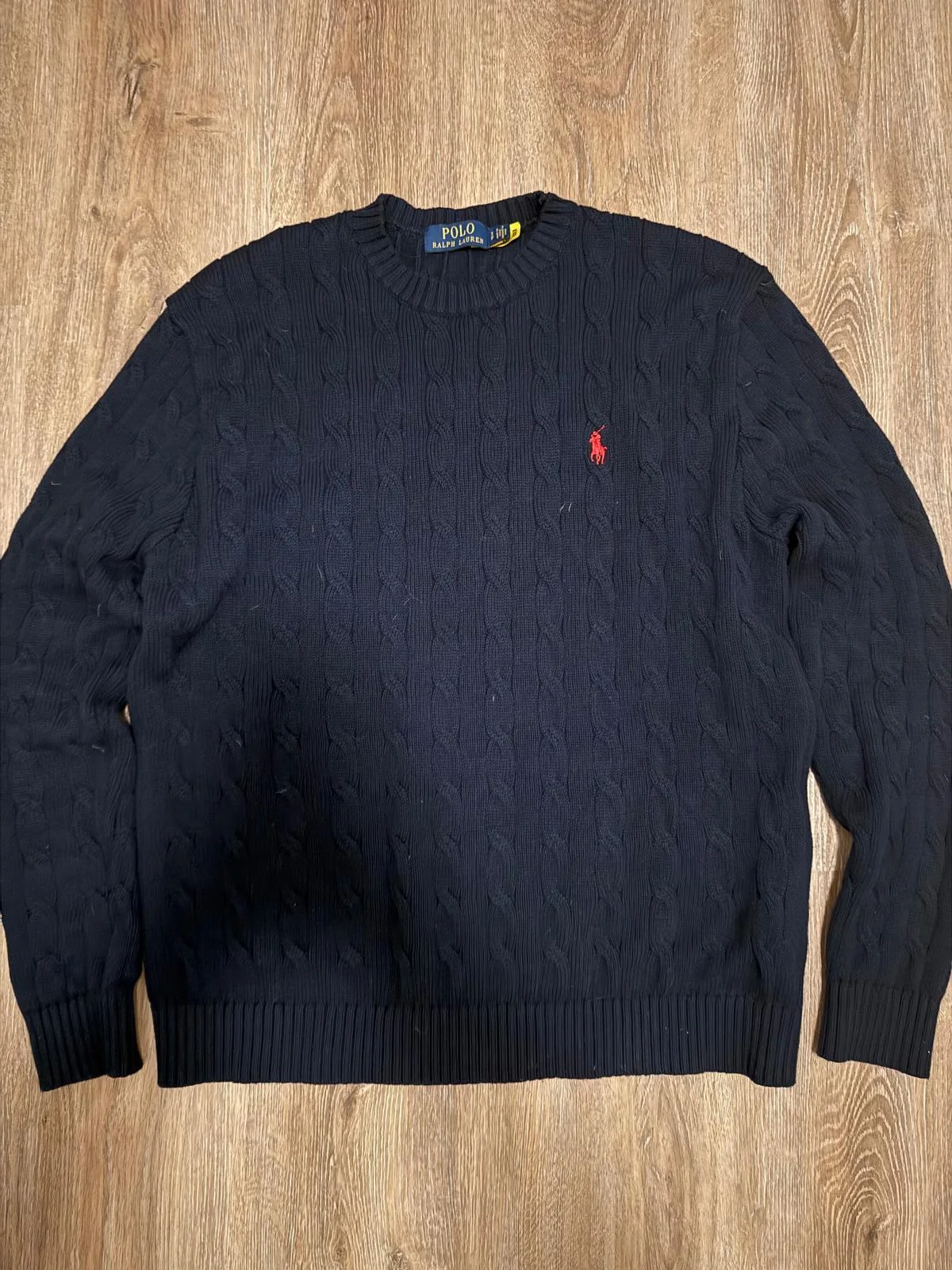 Pull en maille torsadée bleu marine.