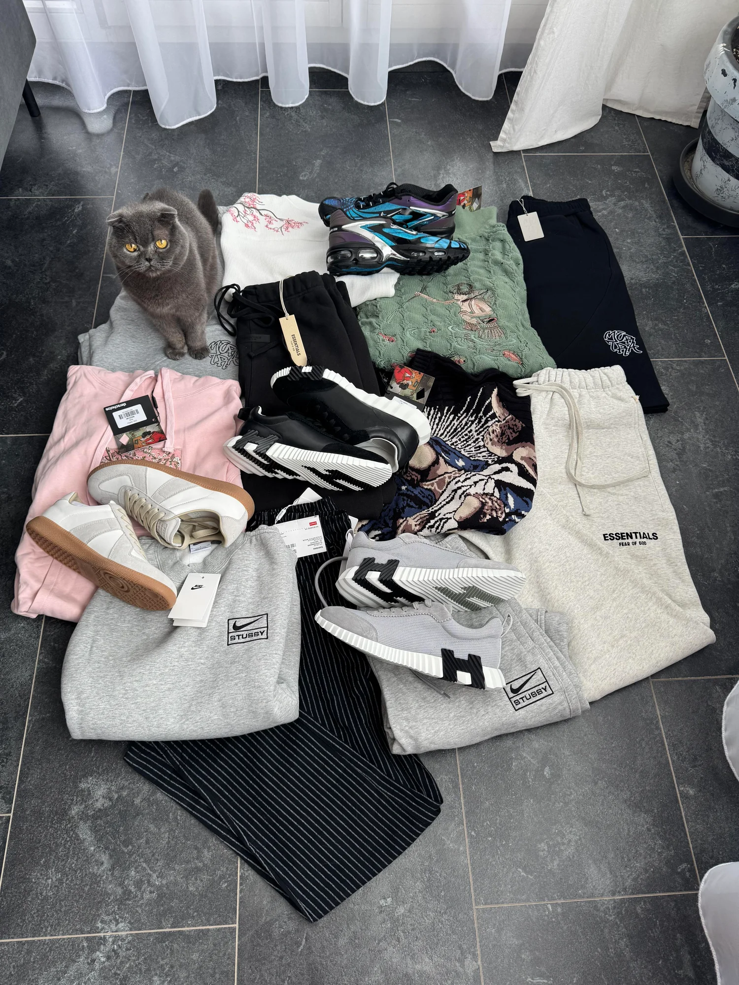 The complete haul, with a cat beside the clothes and shoes.