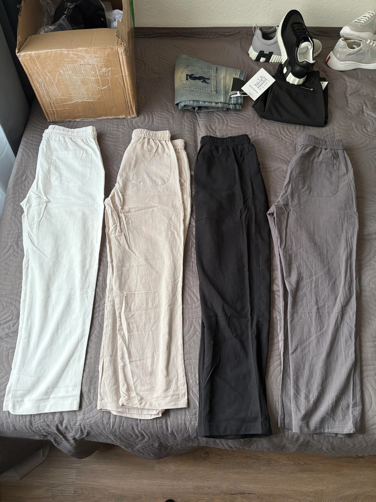 Quatre pantalons de couleurs neutres.