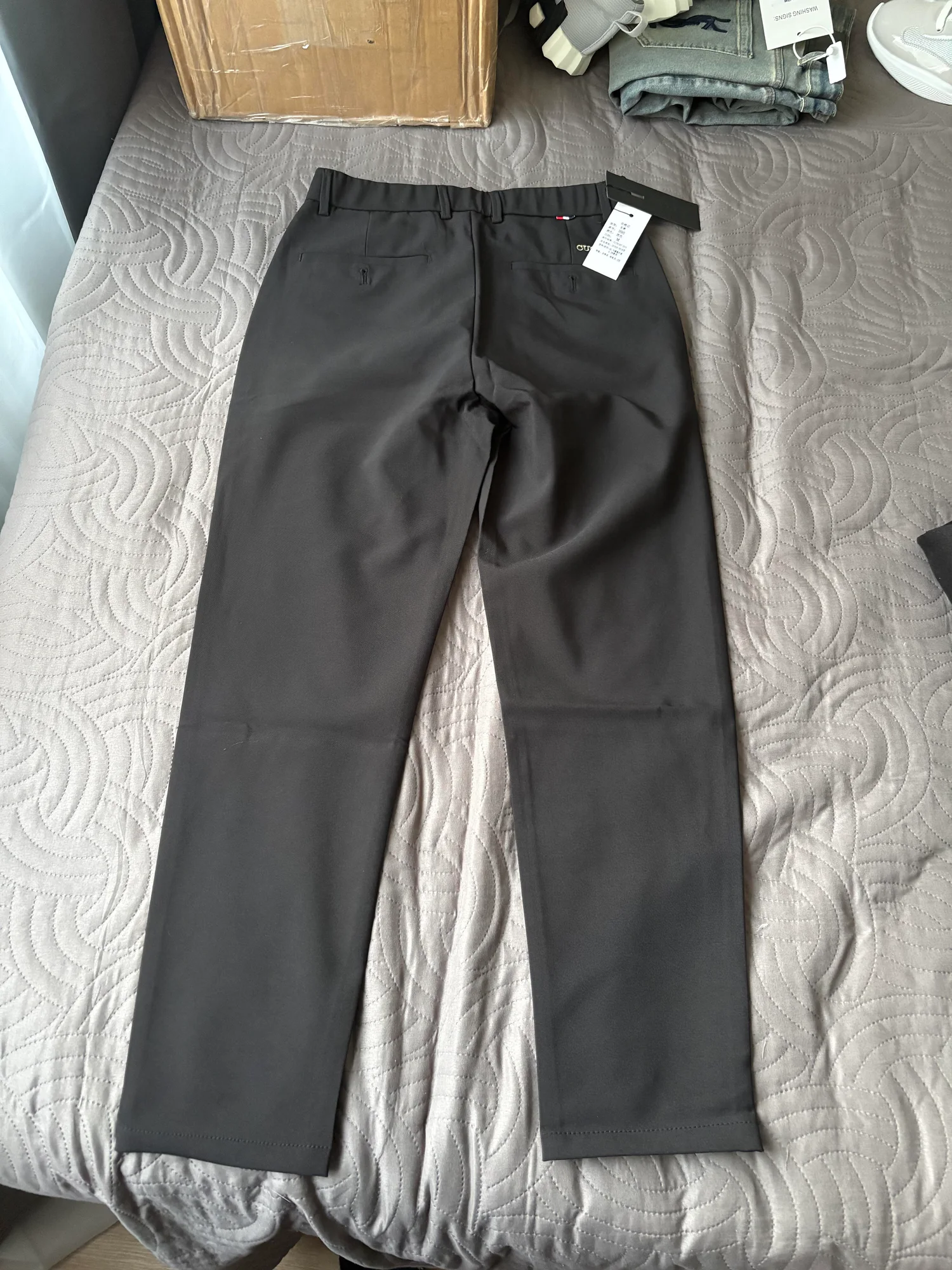 Pantalon formel gris foncé, présenté à plat.
