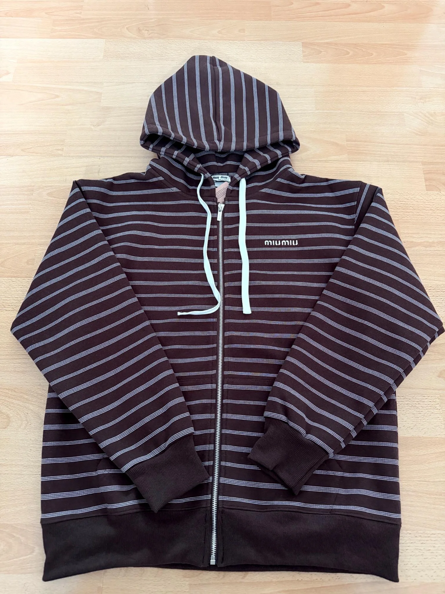 Sudadera con capucha y cremallera de rayas marrones.