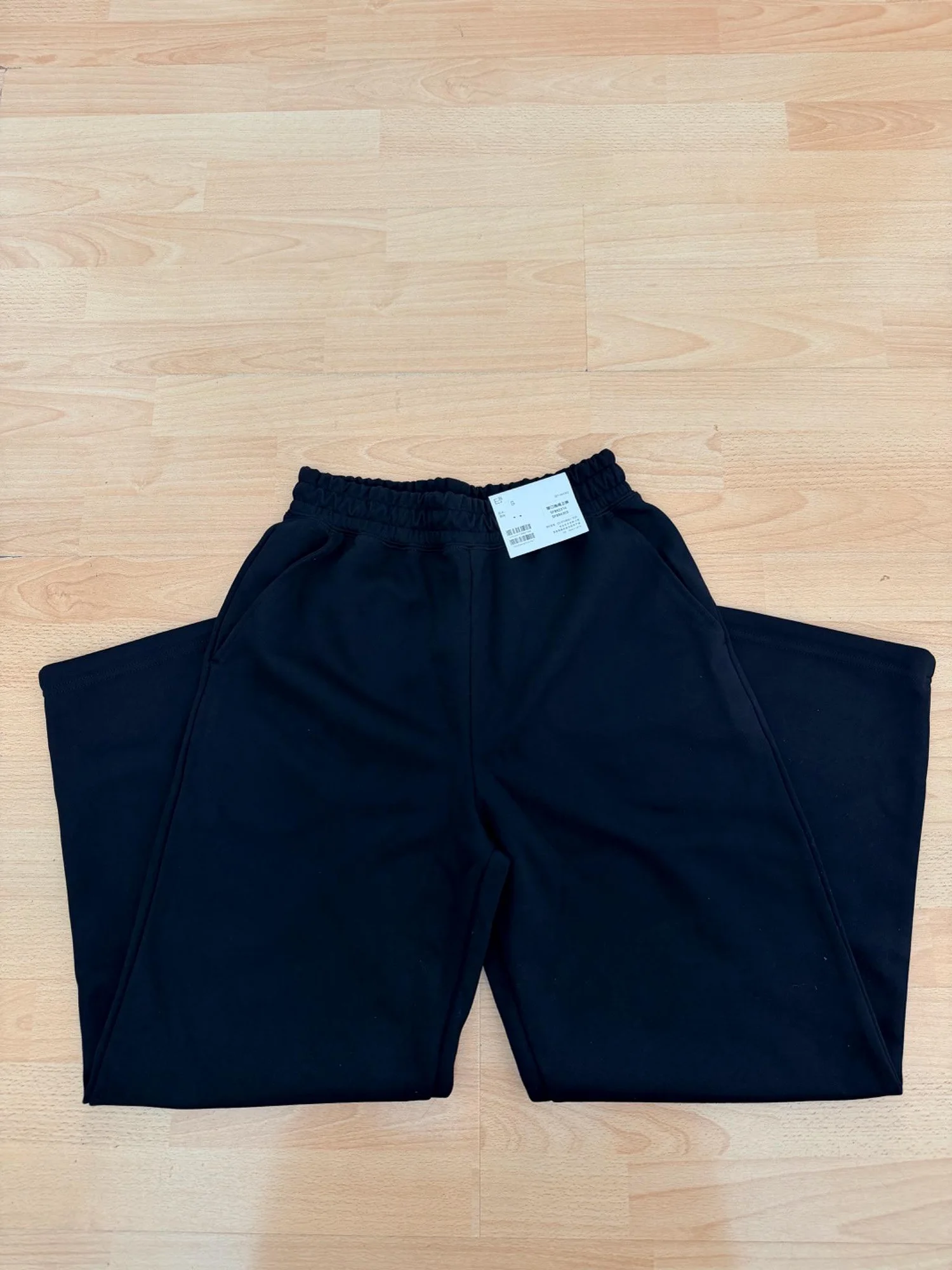 Pantalón de chándal negro con su etiqueta pegada.