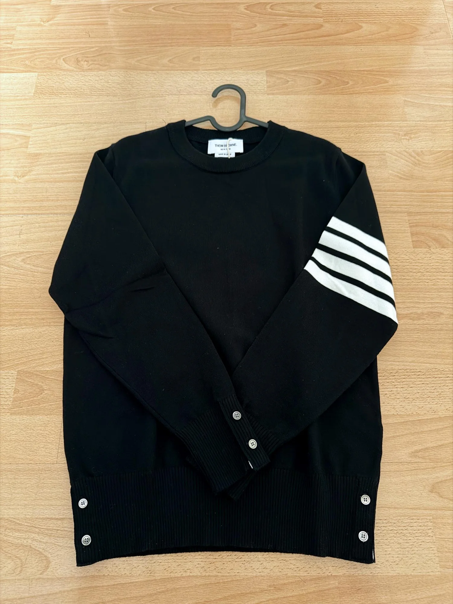 Jersey negro con detalle de manga a rayas.